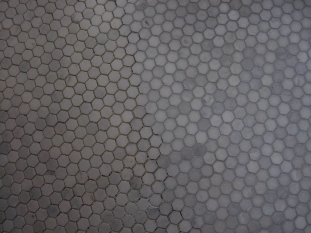 Bathroom hexagon floor tile with stained grout lines