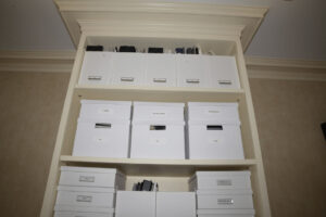 White storage boxes arranged on deep shelves