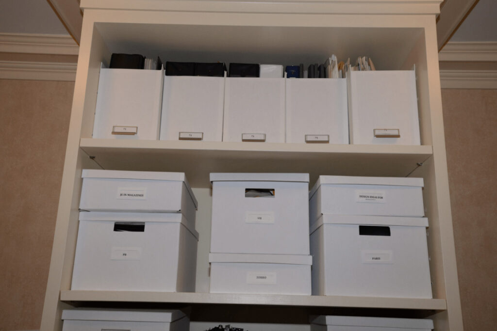 Labeled white storage boxes on open shelves