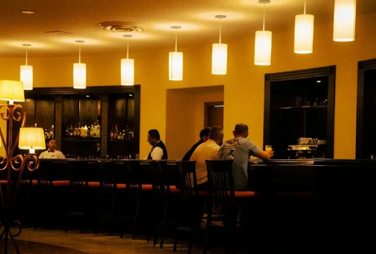 Bar e lounge com balcão e clientes à noite