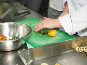 mãos preparando abacaxi na cozinha