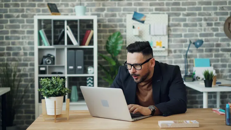 Interior de escritório com mesa de trabalho, computador e documentos financeiros