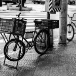Cena de rua em Santos, São Paulo, mostrando bicicletas estacionadas e a vida urbana.