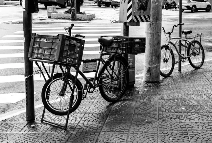 Cena de rua em Santos, São Paulo, mostrando bicicletas estacionadas e a vida urbana.
