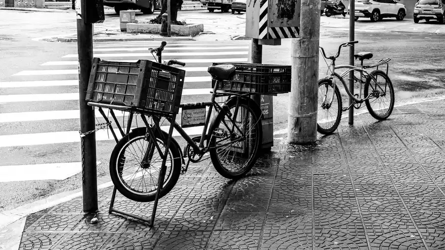 Cena de rua em Santos, São Paulo, mostrando bicicletas estacionadas e a vida urbana.