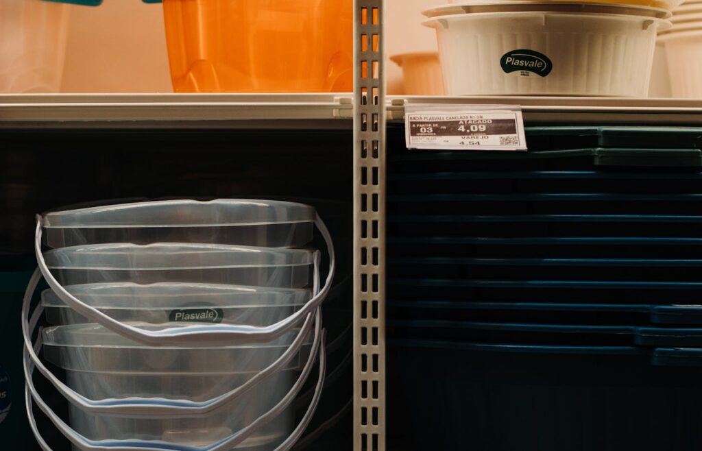 Clear plastic buckets stacked on a store shelf