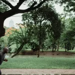 Homem correndo em um parque ao ar livre, em um caminho arborizado.