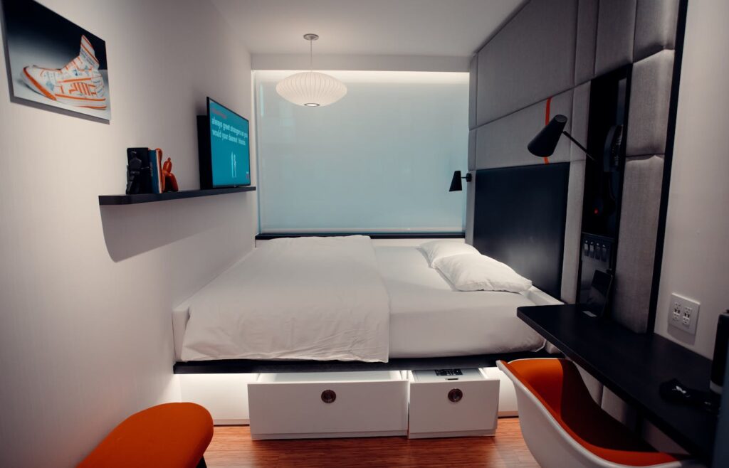 Small bedroom with white storage drawers under the bed