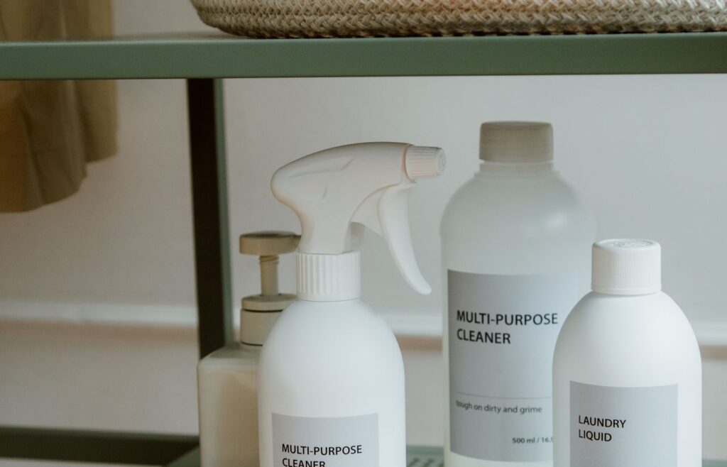 Cleaning brush and bottles arranged on a metal shelf