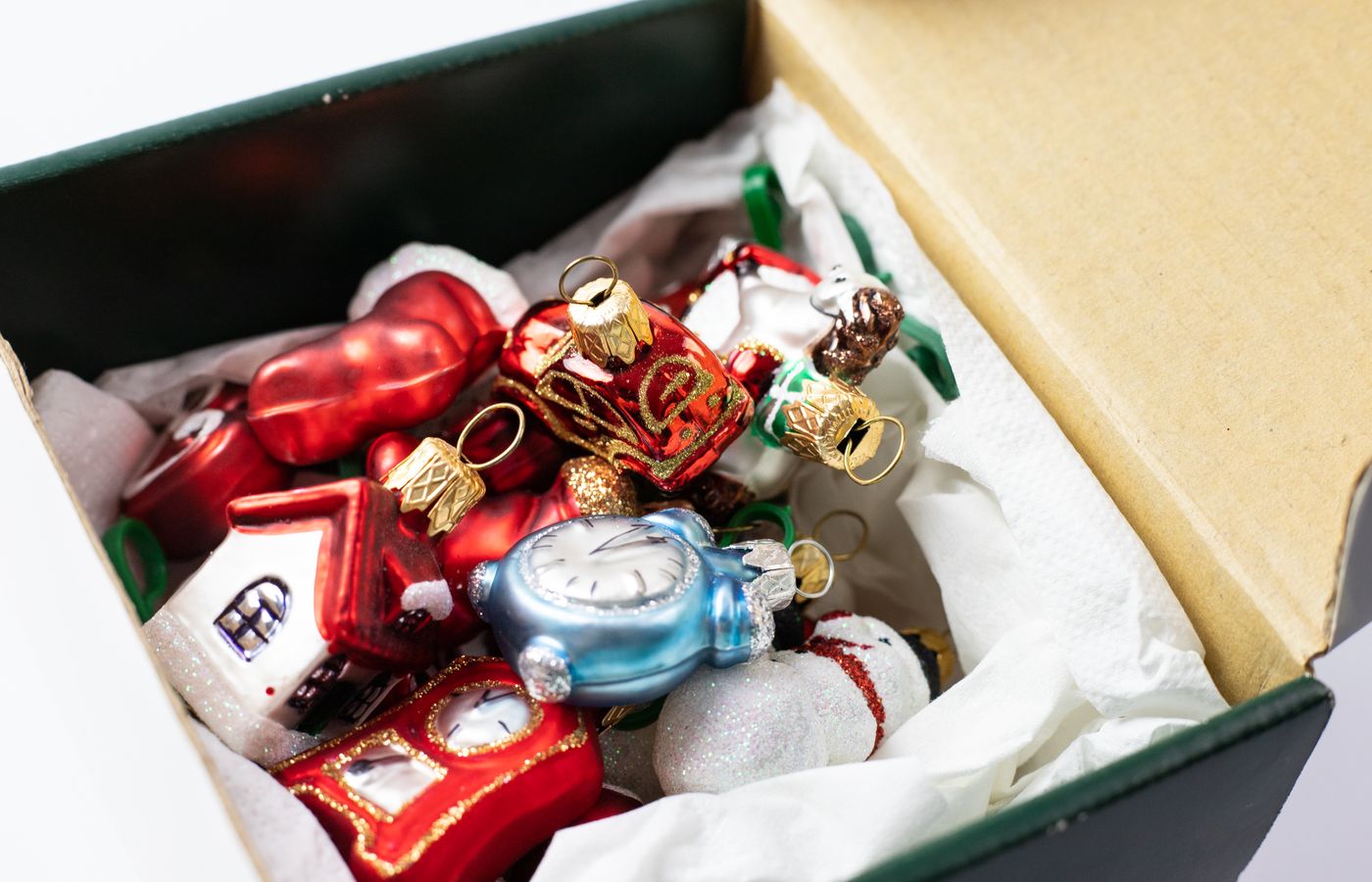 Holiday decor storage box with red and blue ornaments wrapped in tissue paper