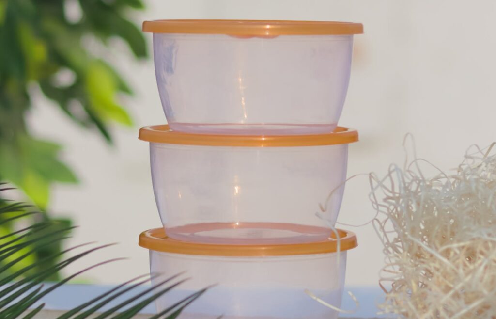 Three clear plastic food containers stacked on a table