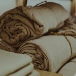 Rolled beige and white towels stacked on a shelf