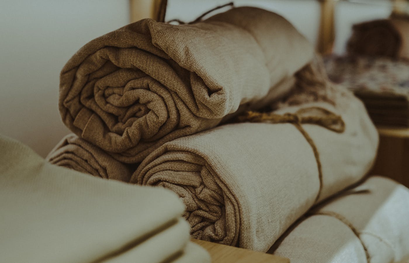 Rolled beige and white towels stacked on a shelf