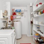 Small laundry room with open shelves and washing machine