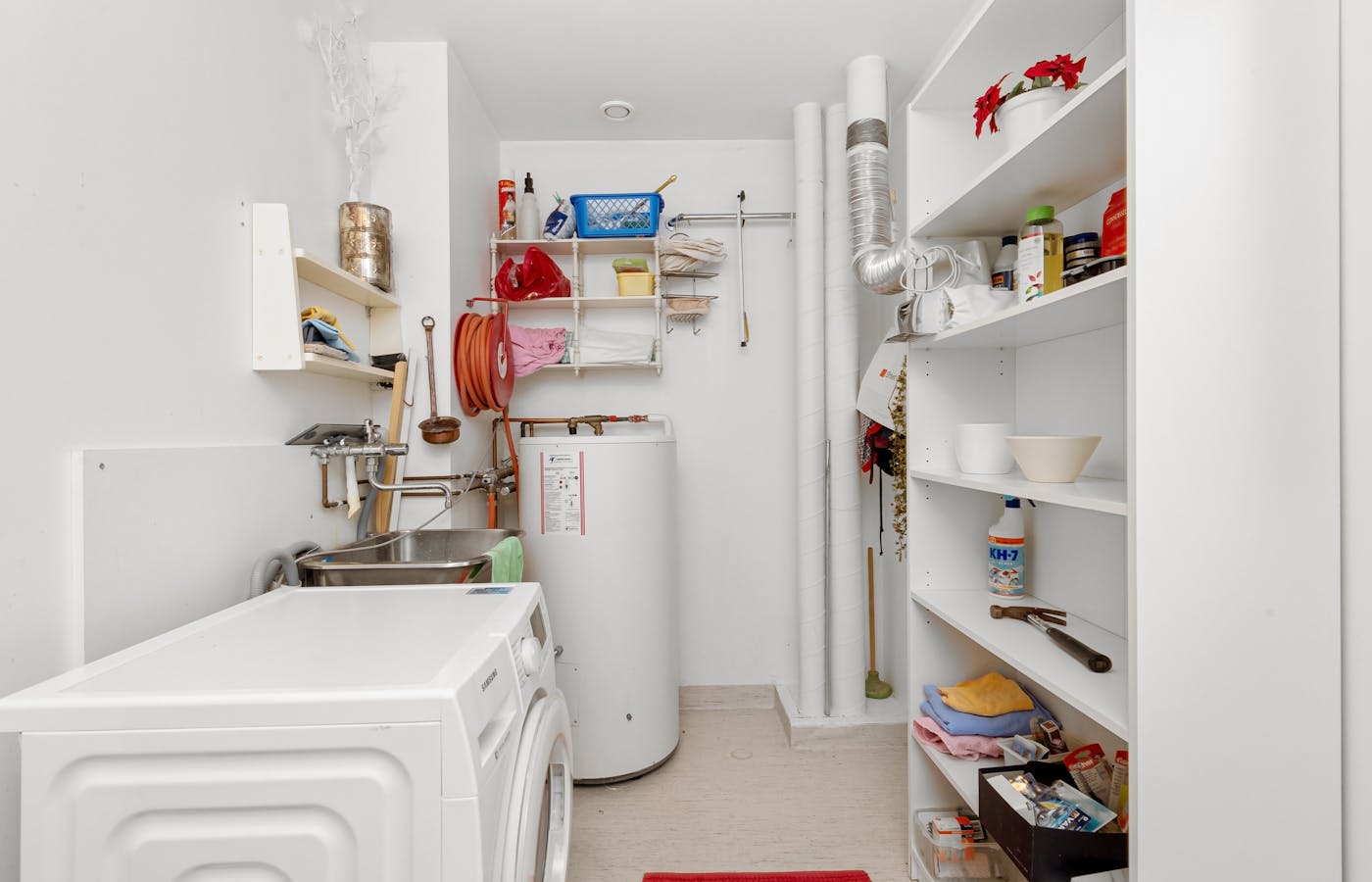 Small laundry room with open shelves and washing machine
