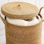 Woven lidded basket holding a white blanket in a bright room