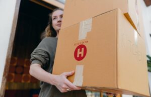 Woman carrying large cardboard boxes while moving