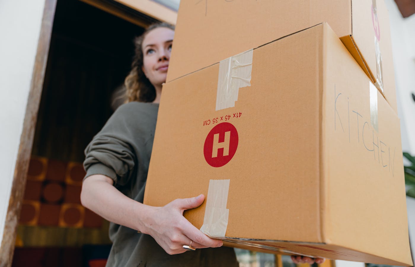 Woman carrying large cardboard boxes while moving