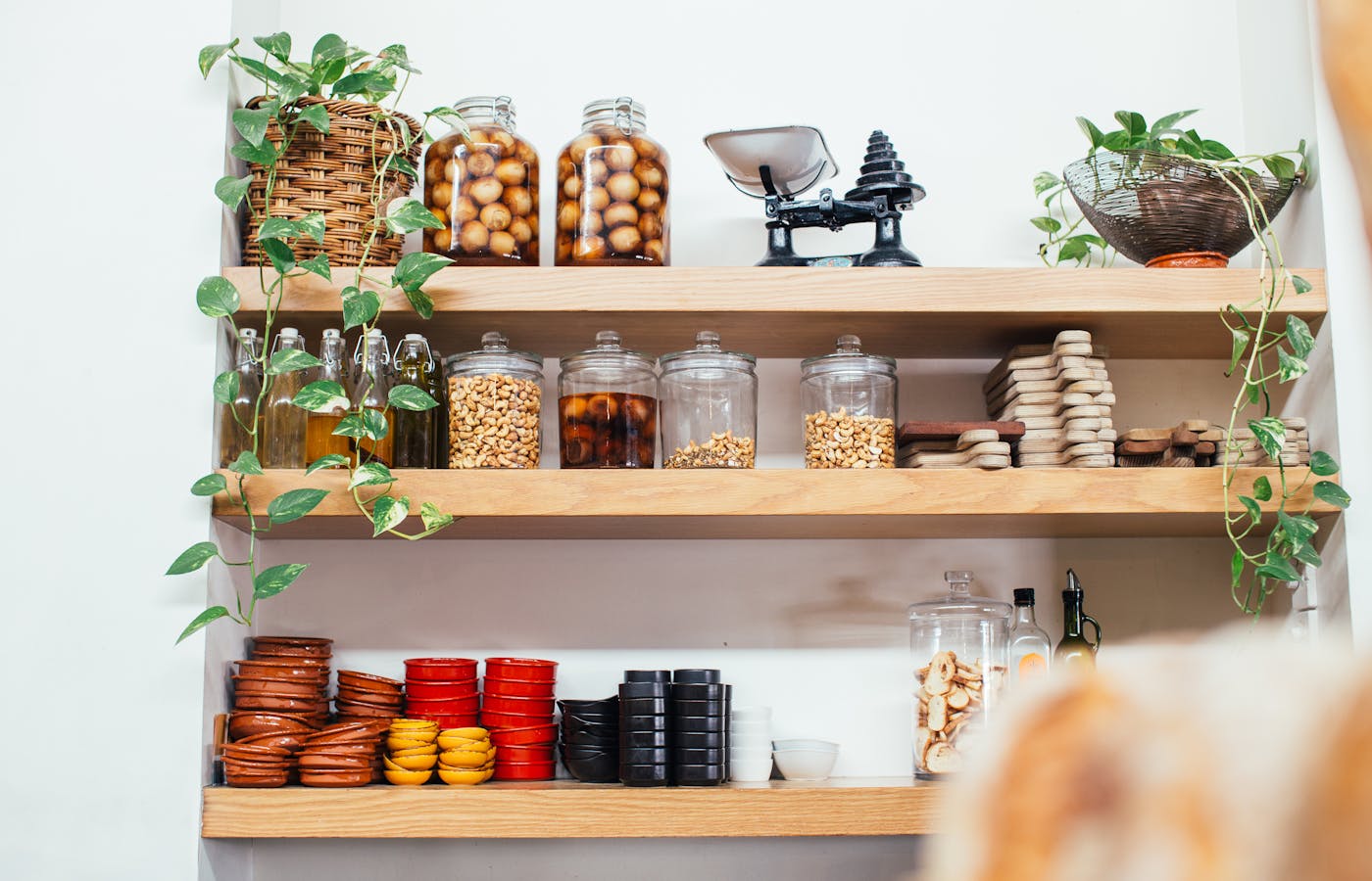 Labeled glass jars and pantry containers on kitchen shelves
