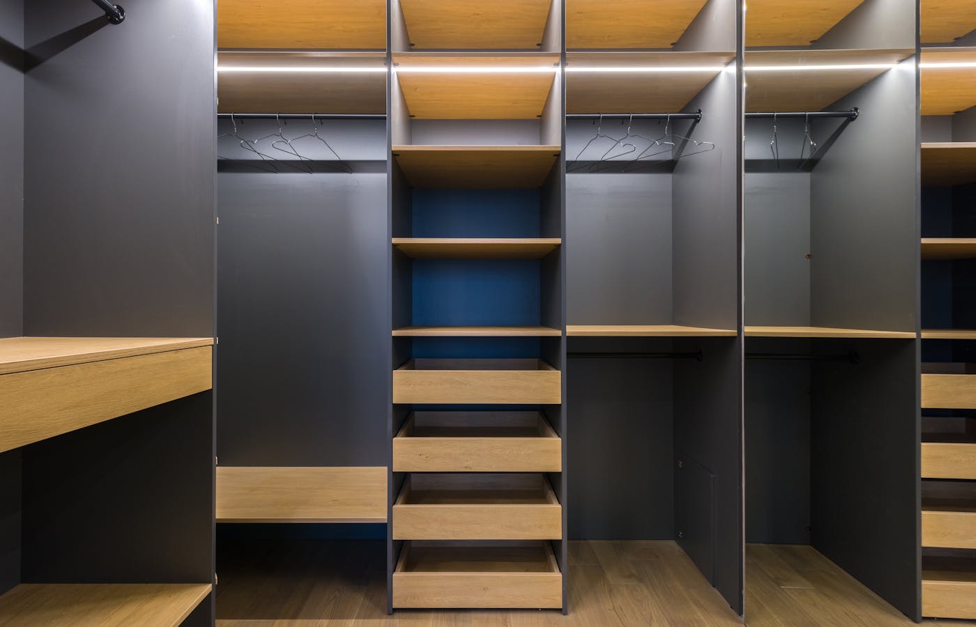 Empty closet with shelves, drawers, and hanging rods