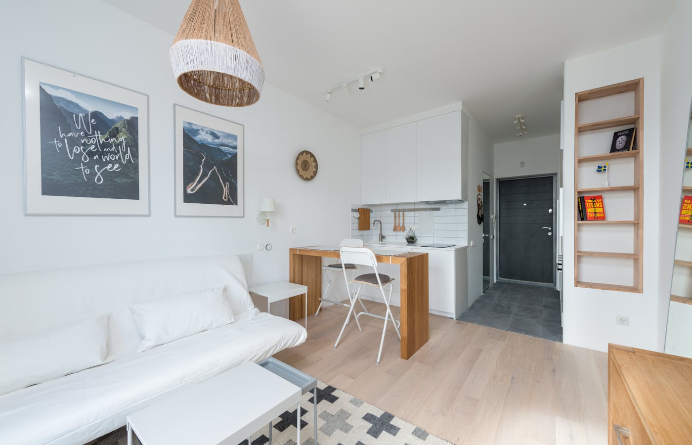 Studio apartment with white sofa small table and compact kitchen