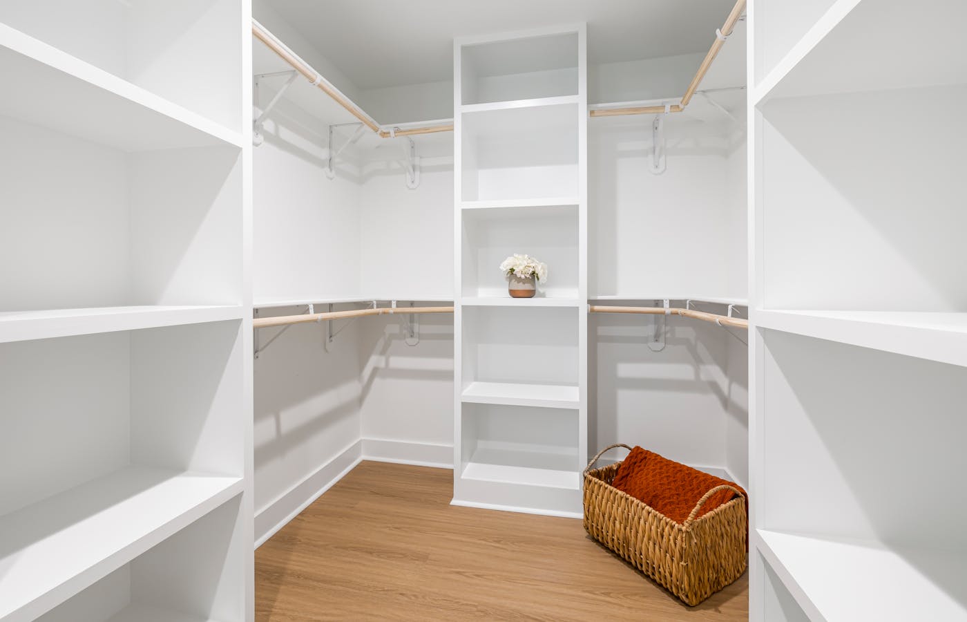 Empty white closet with shelves and a wicker basket