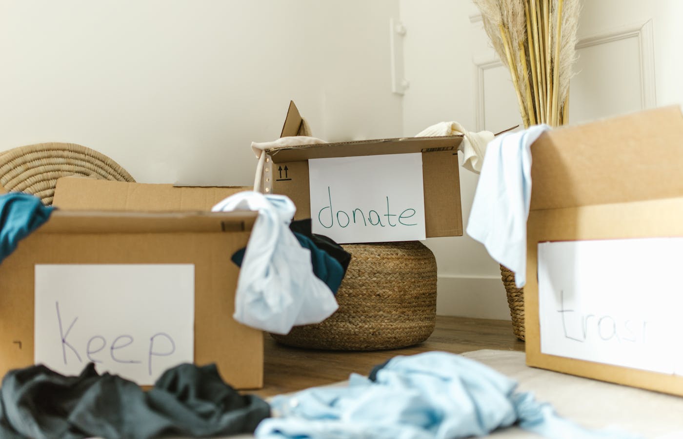 Home organization boxes labeled keep donate and trash on a floor