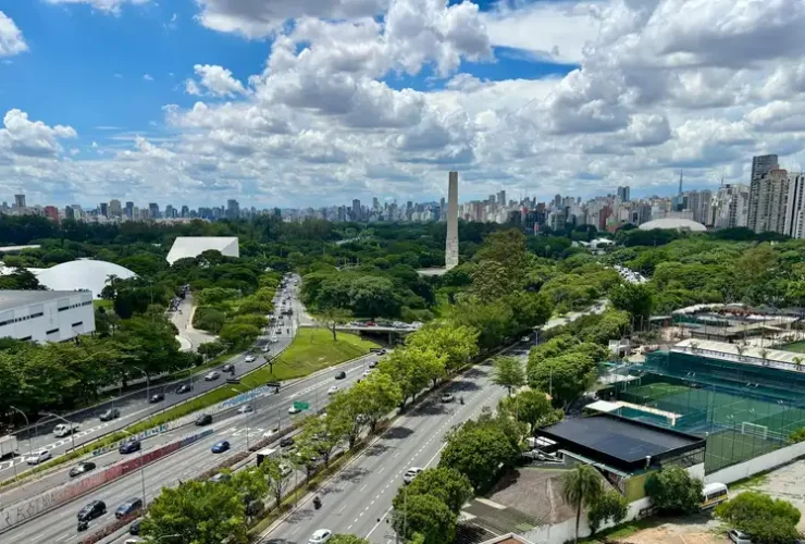 Vista aérea do Parque Ibirapuera, em São Paulo, mostrando vegetação, estradas e o horizonte da cidade.