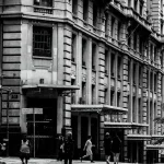 Vista de rua em preto e branco do centro de São Paulo, com pedestres e arquitetura clássica.