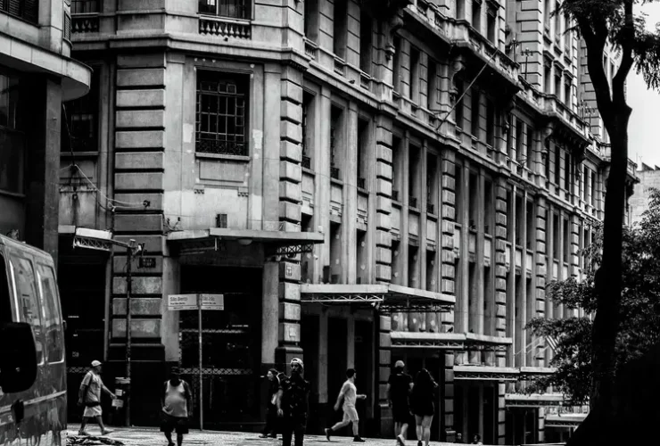 Vista de rua em preto e branco do centro de São Paulo, com pedestres e arquitetura clássica.