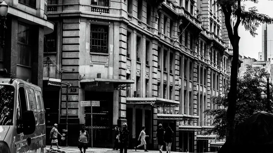 Vista de rua em preto e branco do centro de São Paulo, com pedestres e arquitetura clássica.