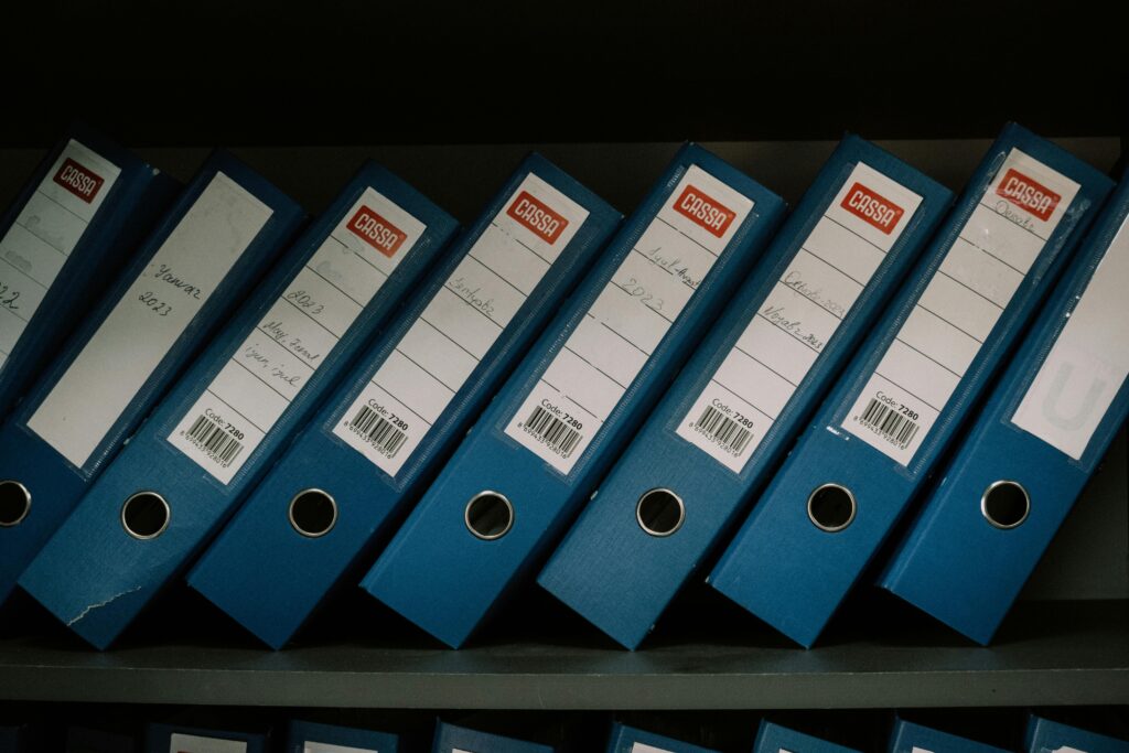 Blue office binders organized on a shelf for home paperwork